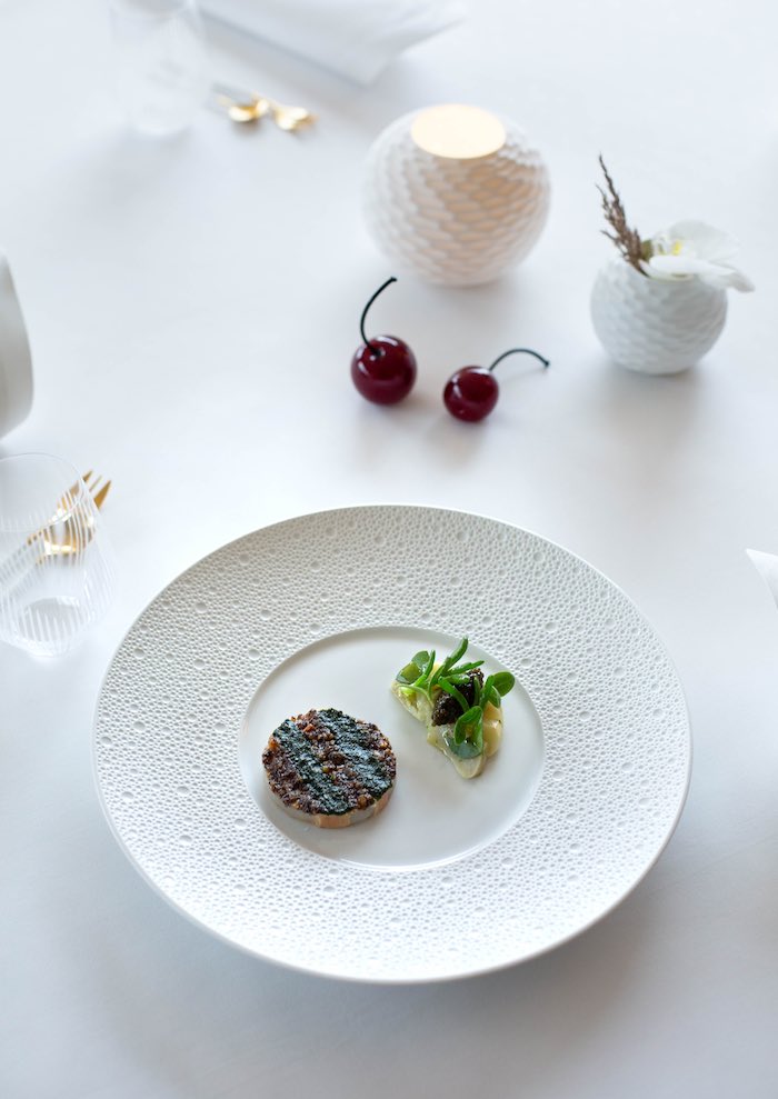 Assiette de Saint-Jacques, vinaigrette aux truffes, salade d’artichauts, herbes salées et caviar Osciètre. © Christophe Urbain