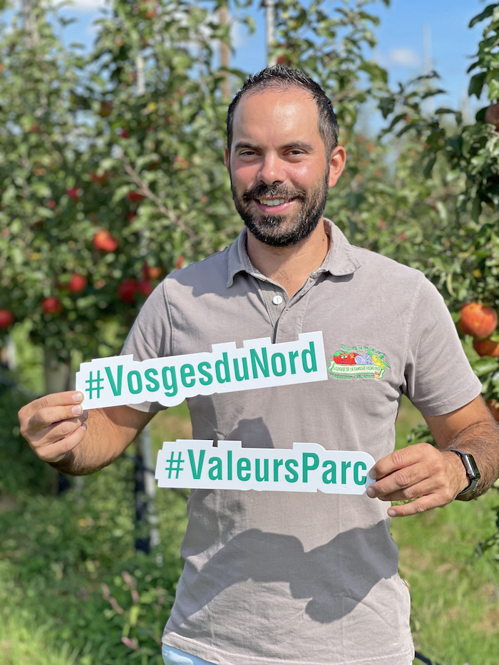 Un employé du verger de la famille Frumholtz mets en avant la marque "Valeurs Parc" des Vosges du Nord